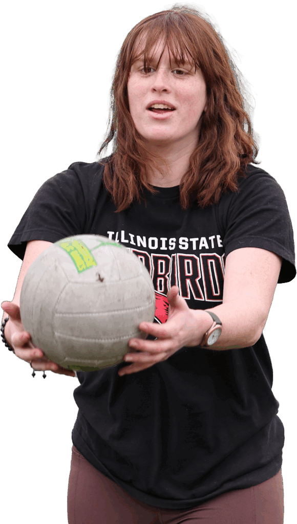Woman in black shirt playing volleyball outdoors.