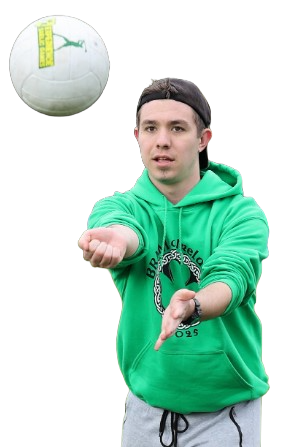Young man in green hoodie practicing volleyball skills with focused expression.