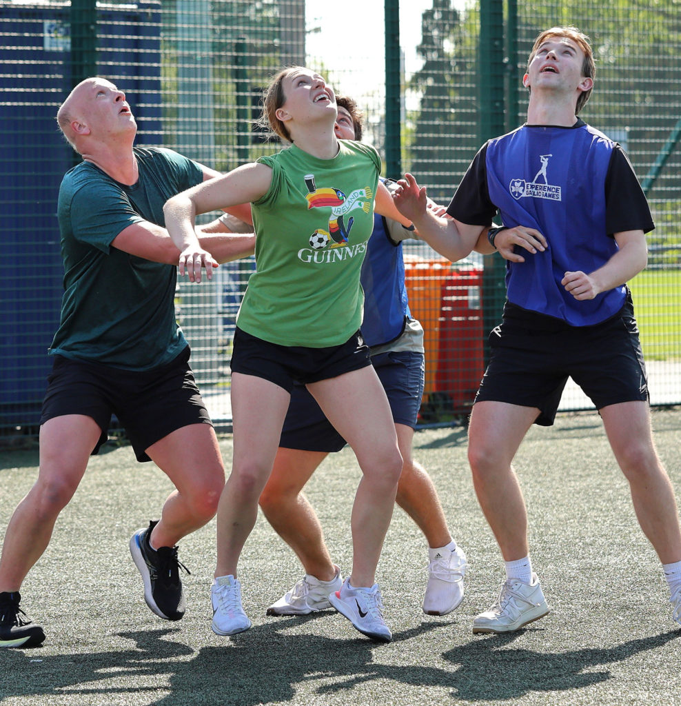 Group playing active outdoor game on sports field, all looking up intently.
