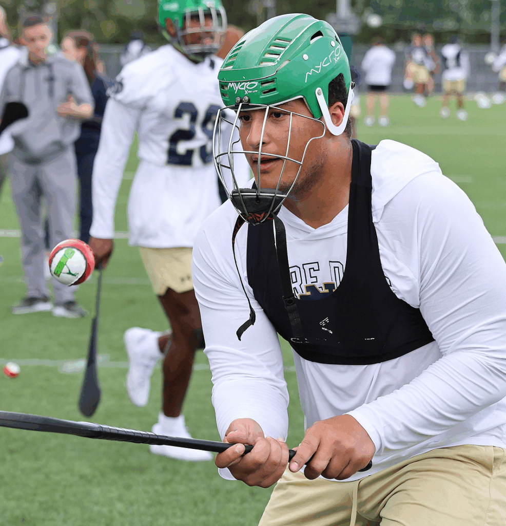 Football player wearing helmet practicing on field with focus and determination.
