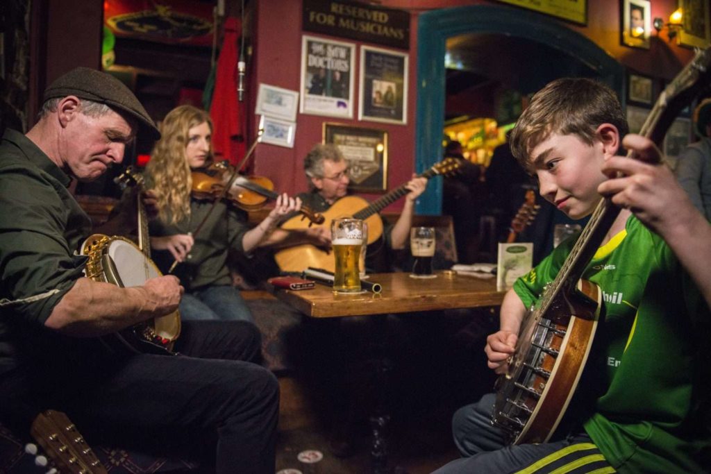Irish musicians playing traditional folk music in a cozy pub setting, with banjos and fiddles.