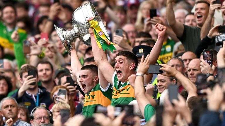 Team celebrates victory, lifting trophy amid cheering crowd at sports event. Joyful moment captured in triumph and excitement.